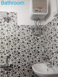 baño con lavabo y pared de azulejos en PRATIMA HOMESTAYS, en Darjeeling