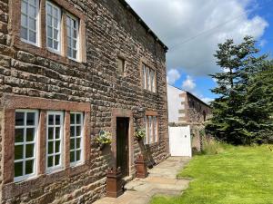 an old brick building with a door and a yard at Marl Hill House in Clitheroe