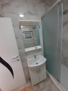 a white bathroom with a sink and a mirror at Villa Abi Center in Struga