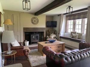 a living room with a leather couch and a fireplace at Marl Hill House in Clitheroe