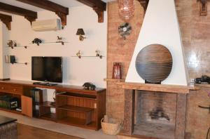a living room with a fireplace and a tv at 5 bedrooms villa with private pool jacuzzi and enclosed garden at Fernan Caballero in Fernancaballero
