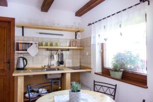 a kitchen with a table and a sink and a window at u Jaňola in Oščadnica