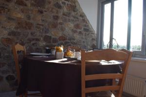 uma mesa de jantar com uma toalha de mesa preta e cadeiras em Auberge de la vallée de la douve em L'Etang-Bertrand