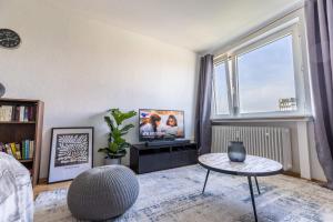 a living room with a tv and a large window at Stilvolles Apartment inmitten der Altstadt in Duisburg