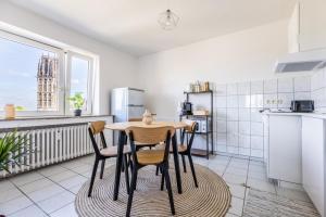 Stilvolles Apartment inmitten der Altstadt في دويسبورغ: مطبخ مع طاولة وكراسي في غرفة