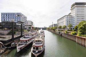 eine Gruppe von Booten, die in einem Fluss in einer Stadt angedockt sind in der Unterkunft Stilvolles Apartment inmitten der Altstadt in Duisburg