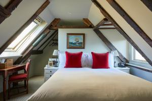 1 dormitorio con cama con almohadas rojas y escritorio en THE PIG-in the wall, en Southampton