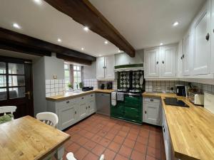 a large kitchen with white cabinets and green appliances at Marl Hill House in Clitheroe