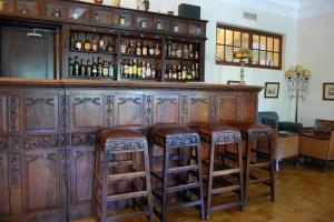 um bar de madeira com bancos num quarto em Hotel Urgeirica em Nelas