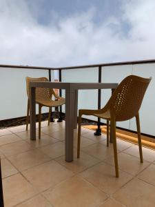 2 sillas y una mesa en el balcón en Apartamentos Los Catorce, EL Hierro en Valverde