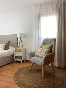 sypialnia z krzesłem, łóżkiem i oknem w obiekcie Apartamentos Los Catorce, EL Hierro w mieście Valverde