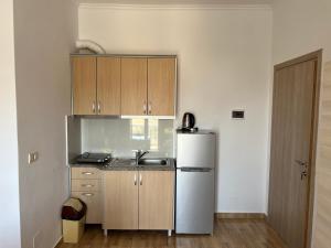 a kitchen with a stainless steel refrigerator and wooden cabinets at Vila Sidi in Ksamil +47 photos