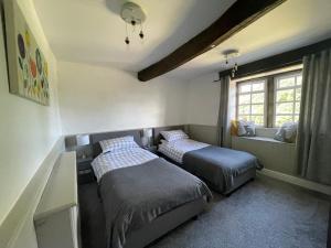 a bedroom with two beds and a window at Marl Hill House in Clitheroe