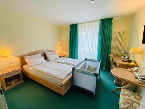 a bedroom with a bed and a desk and a table at Hotel Restaurant Zur Post in Odenthal