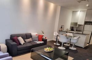 a living room with a couch and a table at Collins central 2-bd apartment with pre-reserve parking in Melbourne
