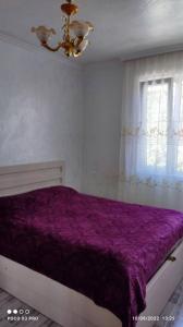- une chambre avec un lit violet et une fenêtre dans l'établissement luka 55, à Khulo