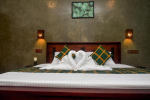 two swans made out of towels sitting on a bed at Villa Evergreen - Hikkaduwa in Hikkaduwa
