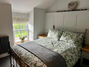 a bedroom with a bed and a window at Gorgeous 2-Bed Cottage in Penderyn Brecon Beacons in Aberdare