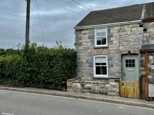 an old stone house on the side of the road at Gorgeous 2-Bed Cottage in Penderyn Brecon Beacons in Aberdare