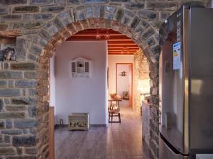 an archway in a kitchen with a refrigerator at VILLA STELLA, LEFKES PAROS in Lefkes