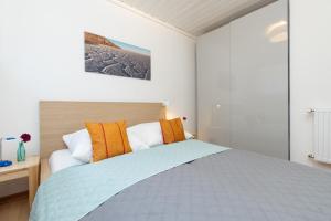 a bedroom with a bed with orange and white pillows at Blankwasserweg 131 Lensterstrand Oase Bungalow 6 in Lenste