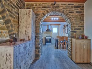 uma cozinha com uma parede de pedra e um arco em VILLA STELLA, LEFKES PAROS em Lefkes