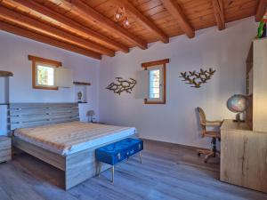 a bedroom with a large bed and a desk at VILLA STELLA, LEFKES PAROS in Lefkes