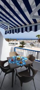 una mesa y sillas bajo una sombrilla en el balcón en Apartamento Oasis Azul, vista oceano. en Puerto del Carmen