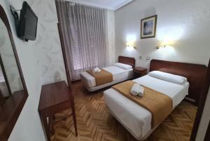 Кровать или кровати в номере Hostal Sardinero