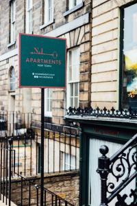 a sign on a pole in front of a building at No1 Apartments Edinburgh - New Town in Edinburgh