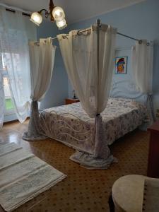 Un dormitorio con una cama con cortinas. en Casa Blu oltremare, en SantʼAntìoco