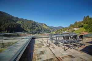 einen Tisch und Stühle auf einem Dach mit Aussicht in der Unterkunft AlpenParks Chalet & Apartment Steve Lodge Viehhofen in Viehhofen