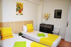 um quarto com 2 camas em amarelo e branco em Double cozy room. Ruzafa - perfect place to stay em Valência
