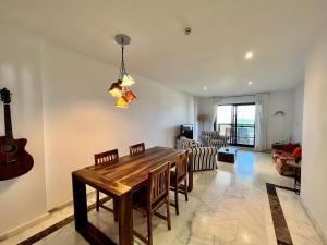 a dining room with a wooden table and a guitar at Quiet & Spacious Apt @ Golf Course w/ Roof Terrace in San Roque