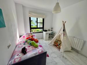 a bedroom with a bed and a play tent at Quiet & Spacious Apt @ Golf Course w/ Roof Terrace in San Roque