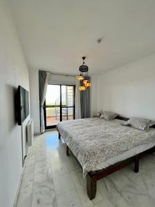 1 dormitorio con 1 cama grande y TV en Quiet & Spacious Apt @ Golf Course w/ Roof Terrace, en San Roque