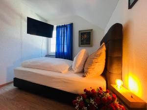 a bedroom with a bed with a blue curtain and a window at Hotel Hirschen Hinwil in Hinwil