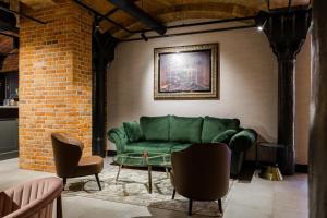 a living room with a green couch and a table at Browar Hevelius Apartments in Gdańsk