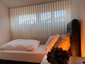 a bedroom with a bed with pillows and a window at Hotel Hirschen Hinwil in Hinwil