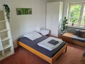 um pequeno quarto com uma cama e uma cadeira em Grüne Wohlfühloase mit einmaliger Aussicht em Königswinter