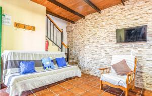 salon z 2 białymi krzesłami i ceglaną ścianą w obiekcie Amazing Home In Casarabonela With Kitchenette w mieście Casarabonela