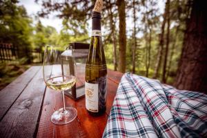 una bottiglia di vino e un bicchiere su un tavolo di legno di Chata Růženka - Národní park České Švýcarsko a Arnoltice