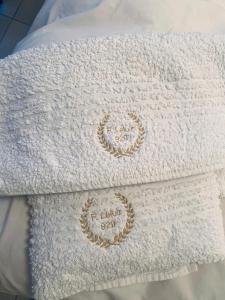 a white towel with two gold embroideredideredideredideredideredideredideredideredidered at Departamentos Leloir in Neuquén