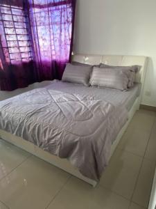 a bed in a room with a purple window at Dwiputra GetAway Homestay in Putrajaya