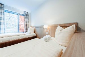 a hotel room with two beds and a window at Gästehaus DEULA in Warendorf