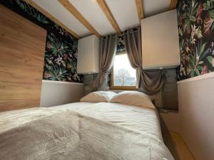 1 dormitorio con 1 cama y una ventana con cortinas en Apartament u Beti, en Opole