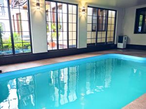 a swimming pool with blue water in a building with windows at Villa Diola in Kosiv