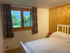a bedroom with a bed and a window at Chalet Olimon in Saint-Jean-d'Aulps