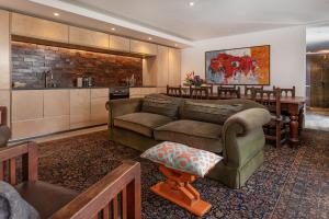 una sala de estar con un sofá y una mesa en 17 Marine Hermanus, Apartment 103 with private Hot Tub, en Hermanus