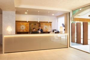 two people sitting at a counter in a room at Hotel Gallia & Resort in Lido di Jesolo